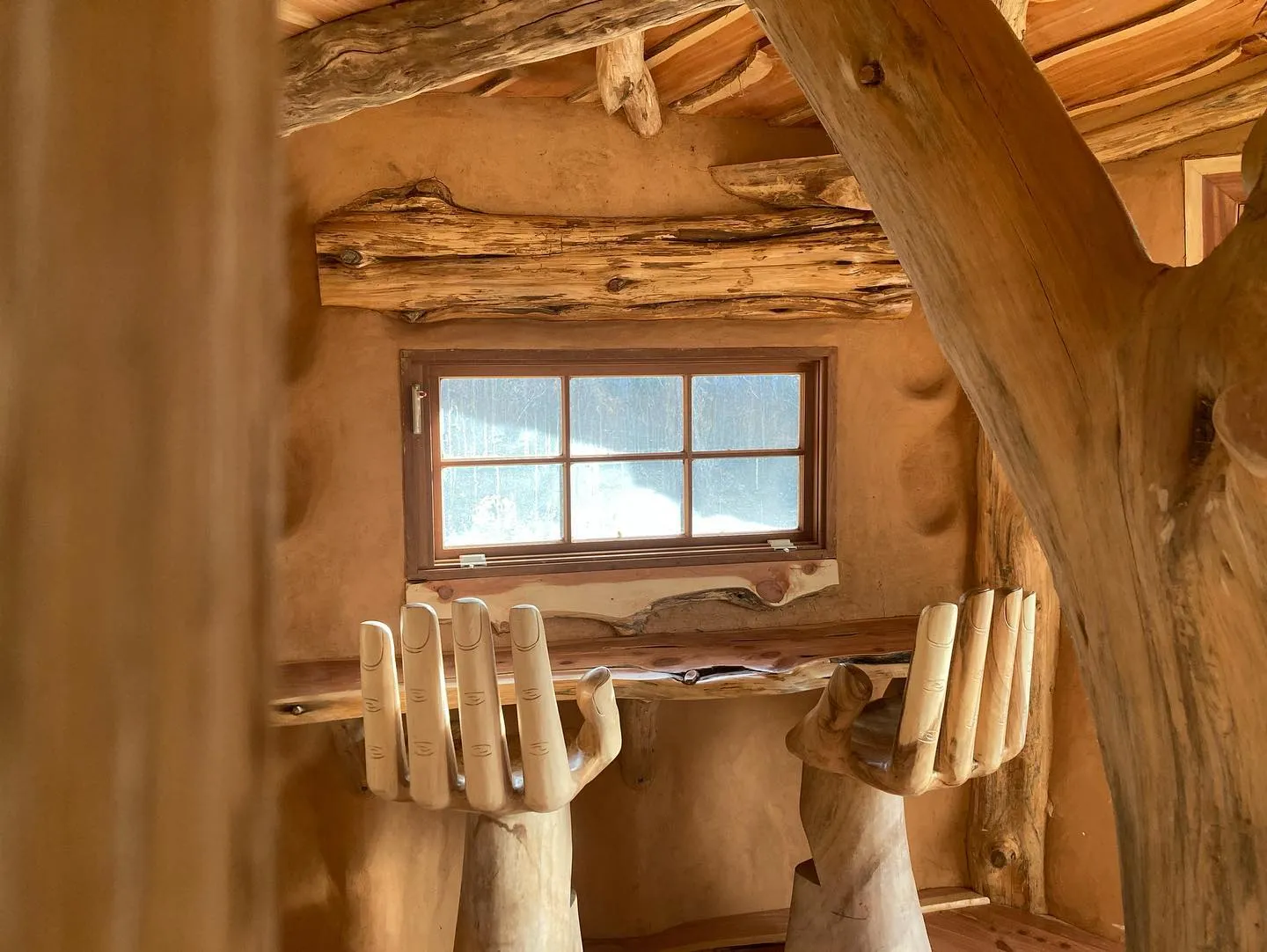 This cob home in Asheville built with wattle and daub features picture windows and hand made furniture.